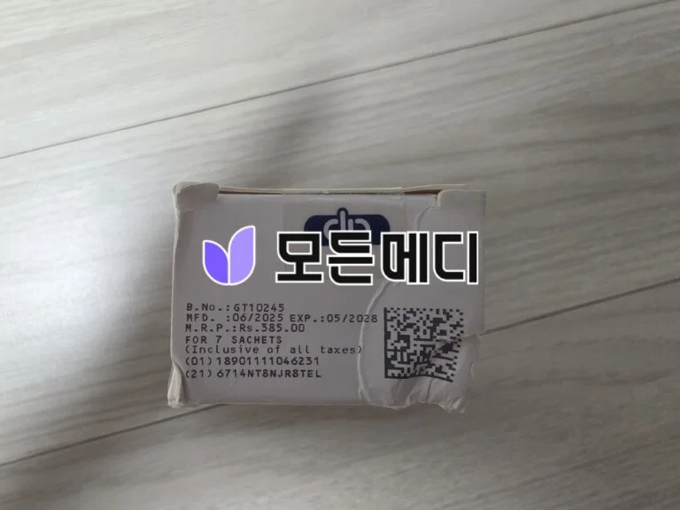 White cardboard package with a printed label showing serial B.No. GT10245, manufacture date 06/2025, expiration 05/2028, plus a QR code and a purple logo.