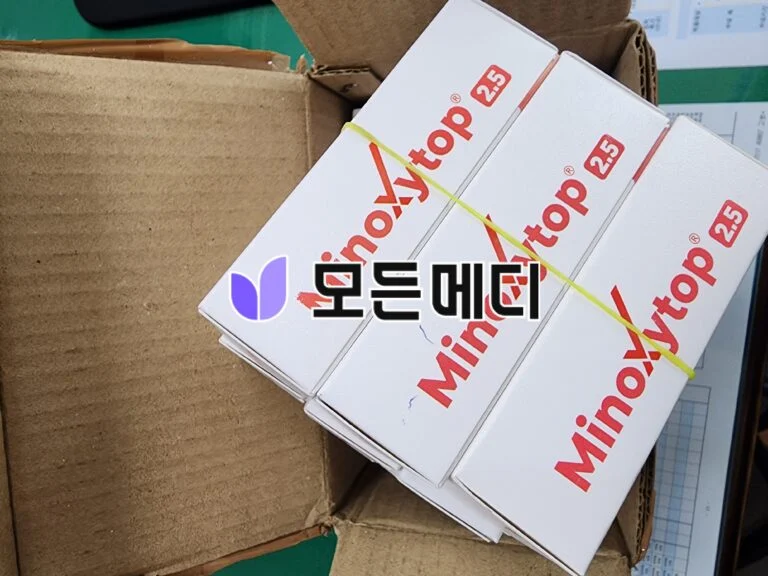 Stack of white boxes with red 'Antop 2.5' branding stacked inside a cardboard crate, secured by a yellow strap.