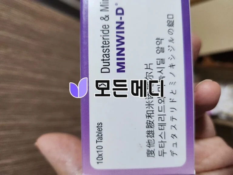 Close-up of a purple-bordered packaging box with the text 'Double Mint' and Japanese writing, held by a hand, with a purple leaf logo visible on the corner.