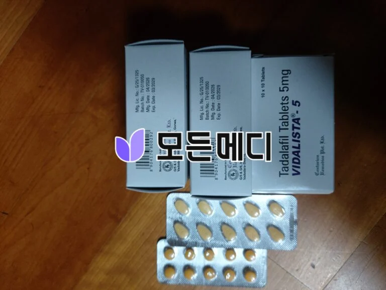 Assortment of medicine packaging: blue boxes and foil blister packs with beige tablets on a wooden surface.