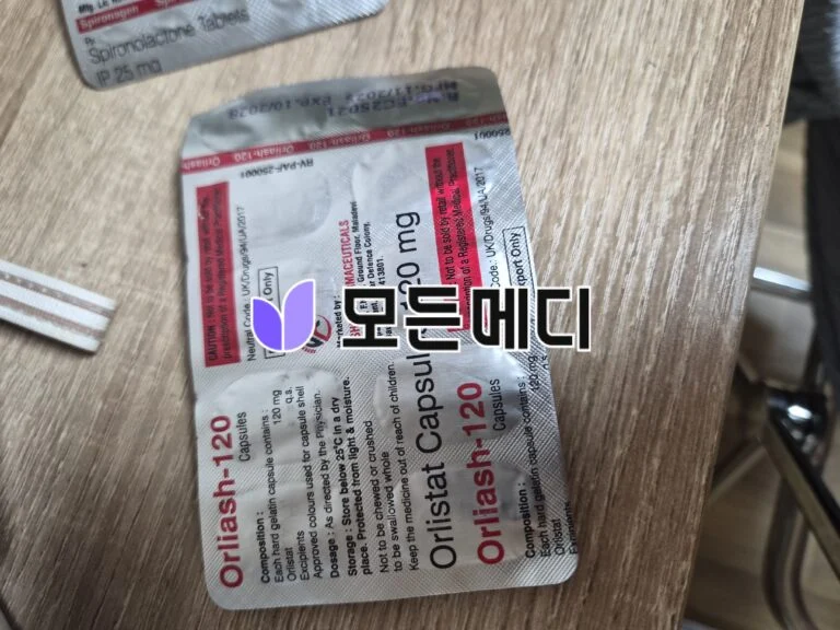 Two blister packs of medication on a wooden surface, with red-and-white labeling and bold dosage text visible on the packaging.
